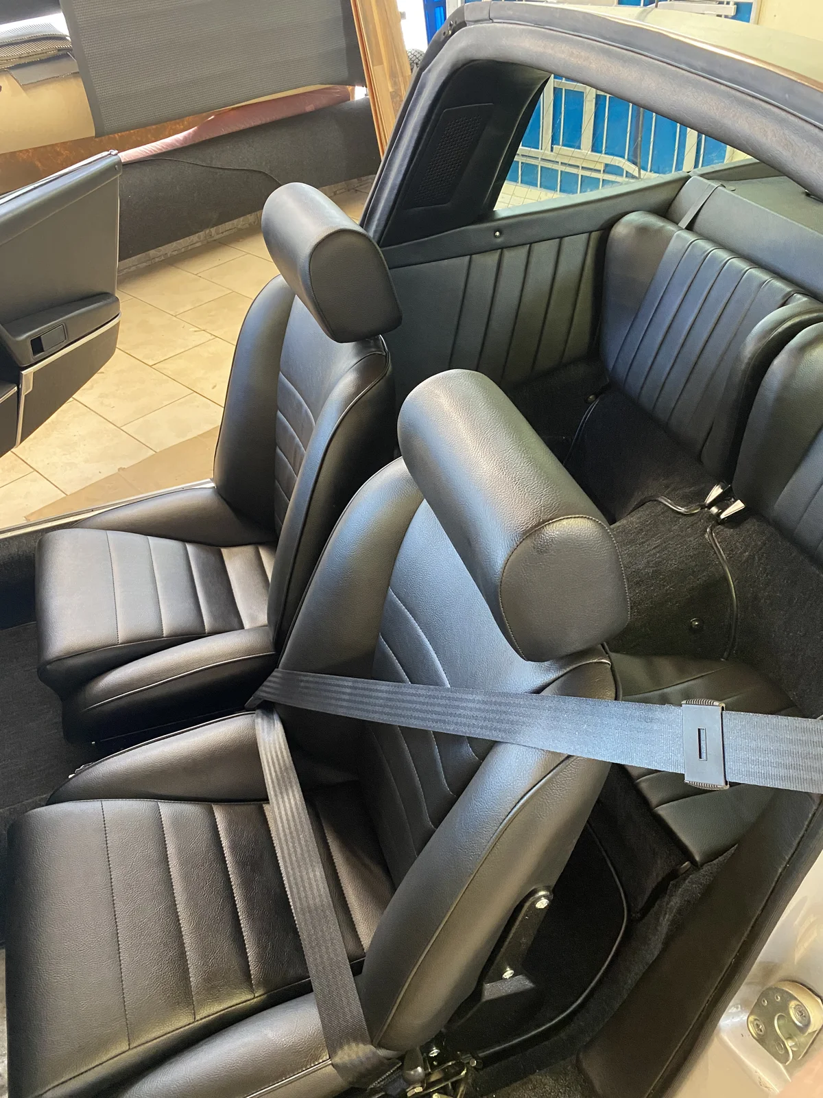 Porsche 911 cabin with black leather seats and seat belts
