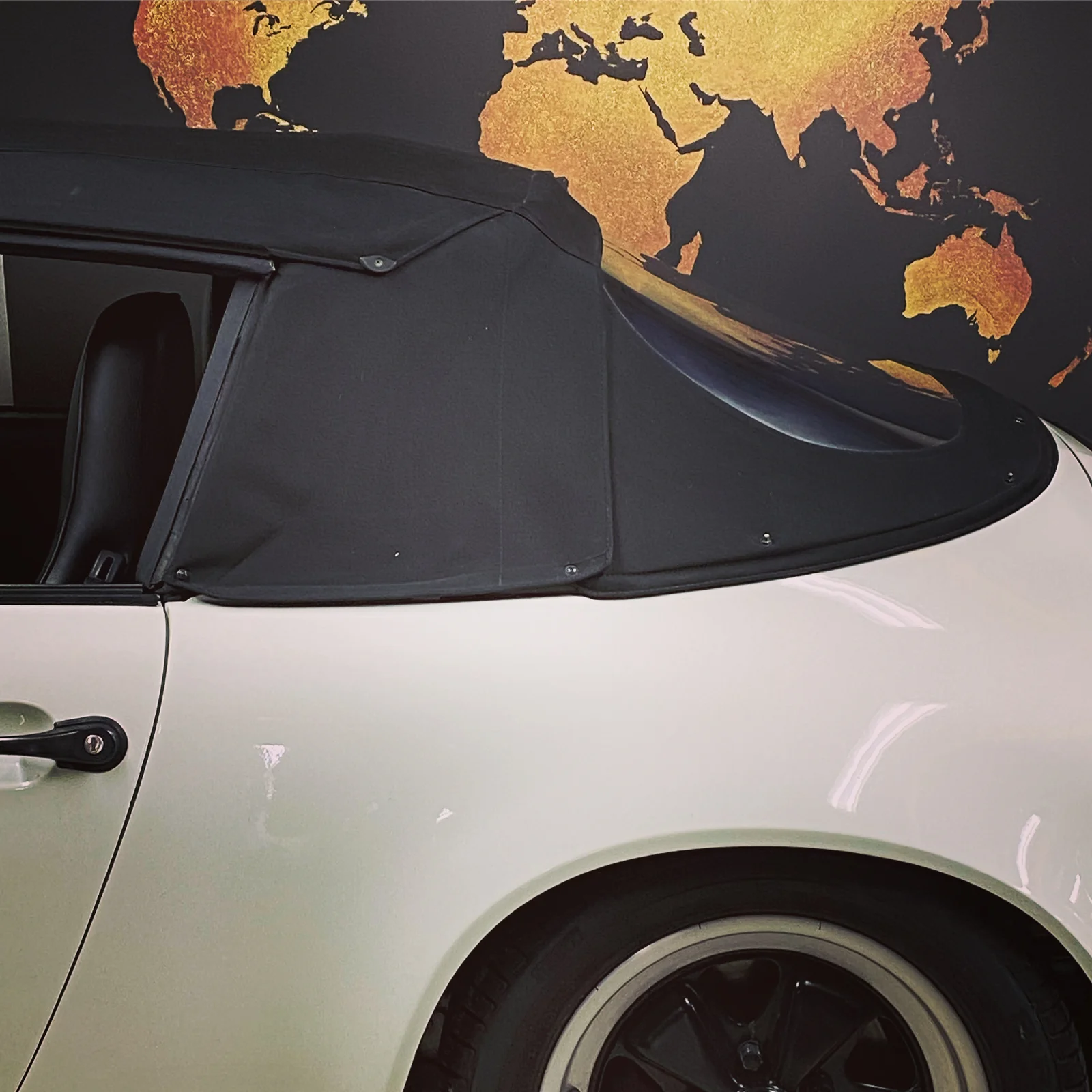 Detail of black soft top on Porsche 911 Cabriolet in showroom