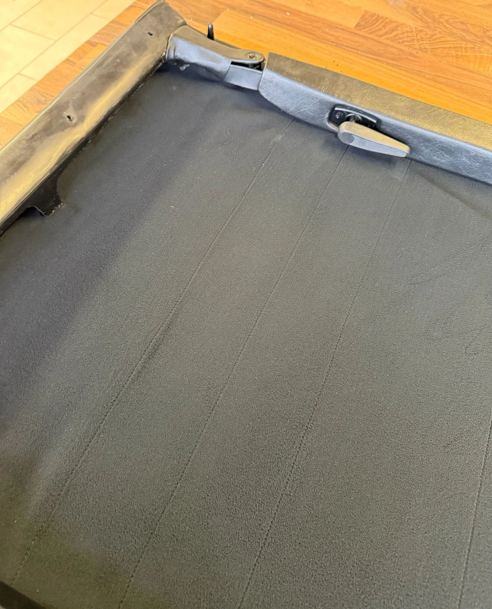 Restored Porsche Targa roof, side view on the workbench